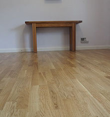 a picture of a wooden floor in a house with a table 